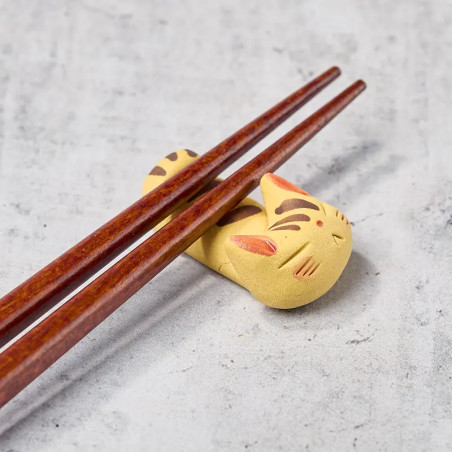 Sleeping white cat chopstick rest